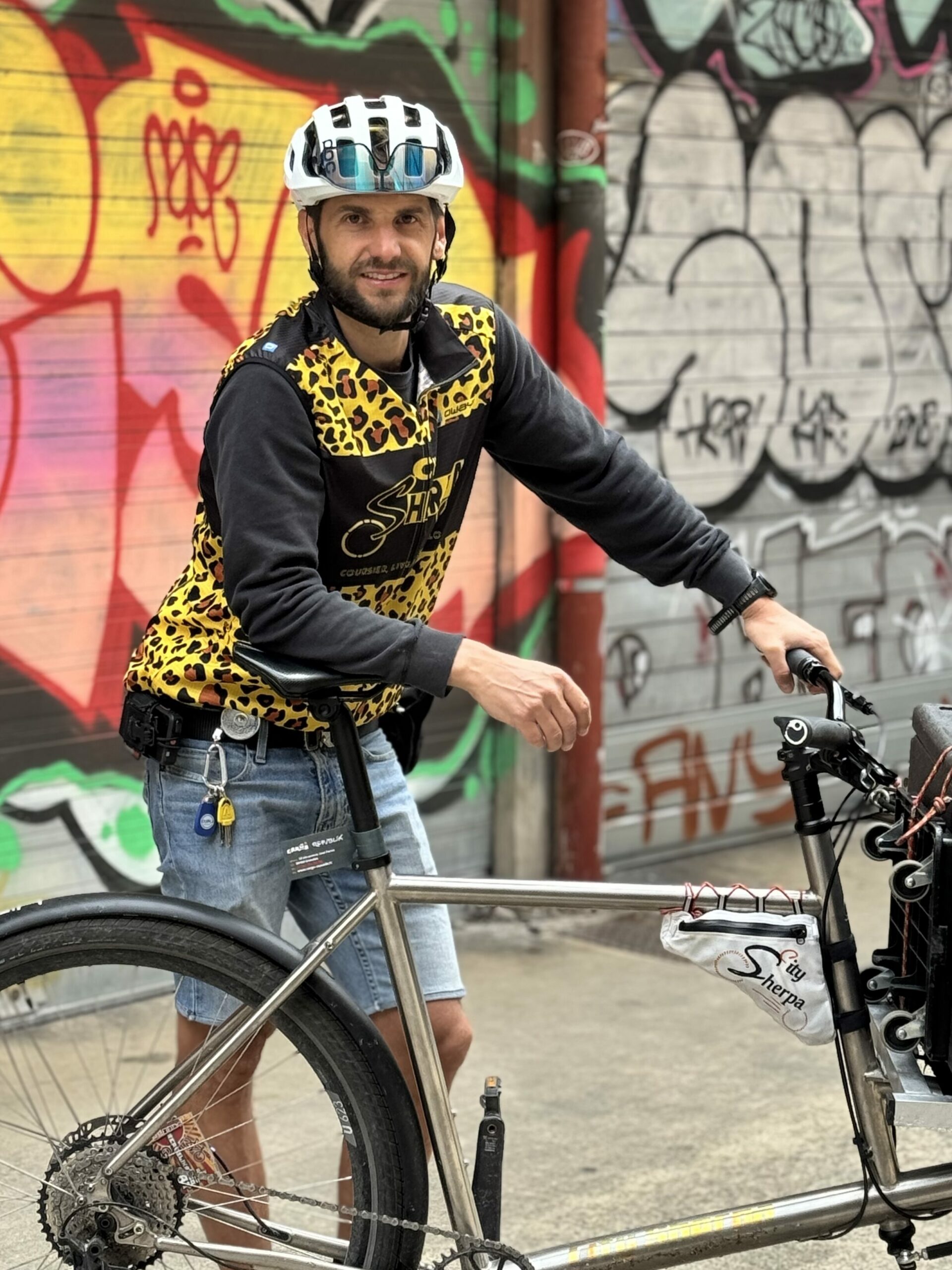 Cycliste urbain devant mur couvert de graffitis